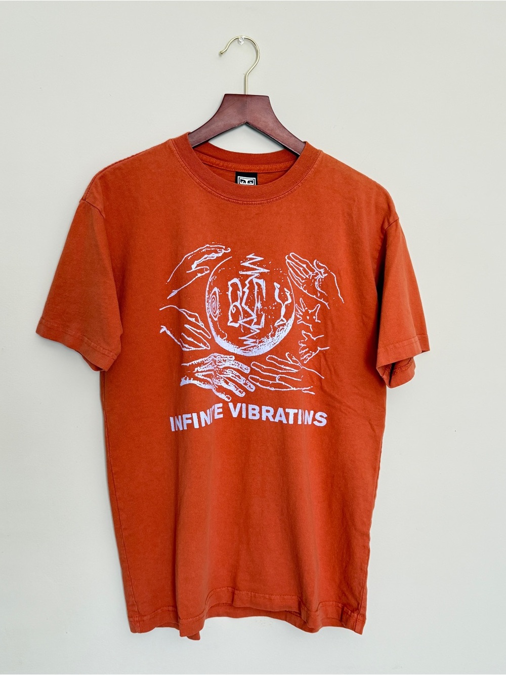 Rust Orange Graphic Tee with White 'Infinite Vibrations' Print
